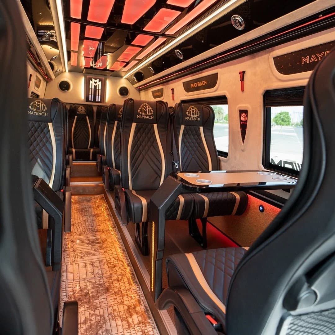 Салон Mercedes-Maybach Sprinter с креслами Maybach, откидными столиками и подстаканниками при тёплой атмосферной подсветке