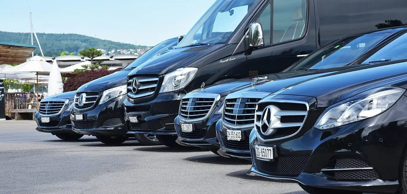 A lineup of black Mercedes chauffeur sedans and vans parked side by side