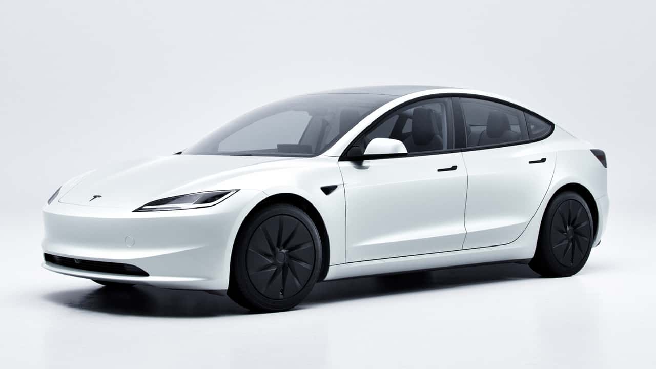 Вид спереди сбоку на белую Tesla Model 3 в студийной съёмке