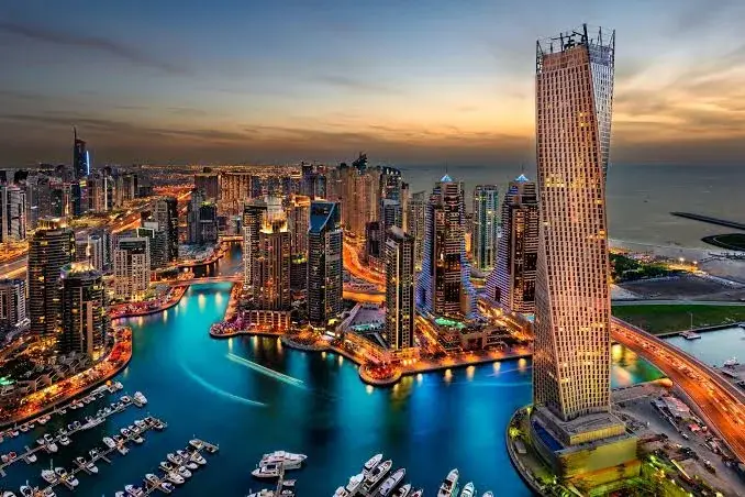 Aerial view of Dubai Marina at sunset with the Cayan Tower and marina waterfront