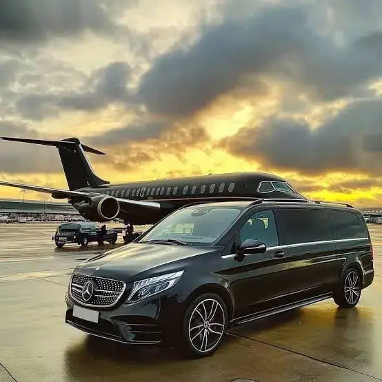 Apex Limo Mercedes V-Class parked on the tarmac beside a private jet at dusk, ready for an airport transfer