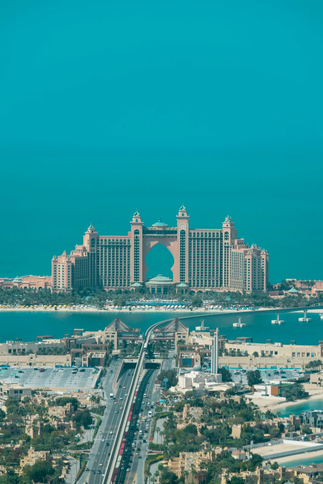 Luxury resort courtyard and pool lined with palm trees on Palm Jumeirah at dusk
